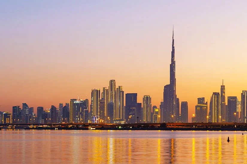 Dubái al atardecer con el Burj Khalifa, un perfil urbano moderno, la costa e infraestructura urbana.